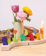 Grimm's seasonal dwarf decorative figures on a celebration ring along side tulip decorative figures and candles. 