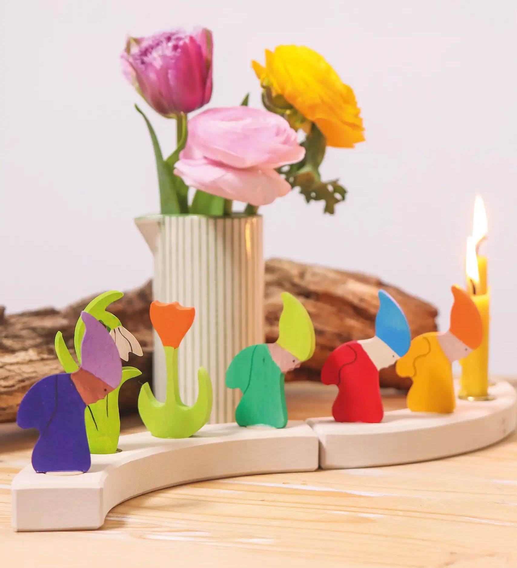 Grimm's seasonal dwarf decorative figures on a celebration ring along side tulip decorative figures and candles. 