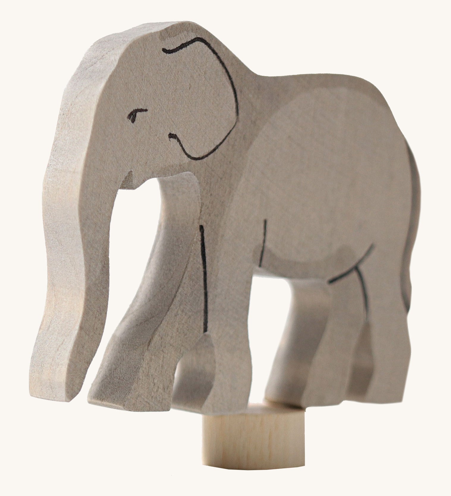 A close up of the Grimms wooden elephant decorative figure showing the hand painted facial features and thickness of the figure