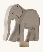 A close up of the Grimms wooden elephant decorative figure showing the hand painted facial features and thickness of the figure