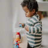 Child stacking a loose blue disk from the Grimms fabuto set