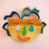 A playful abstract face made from Grimms natural wooden building boards and other building blocks