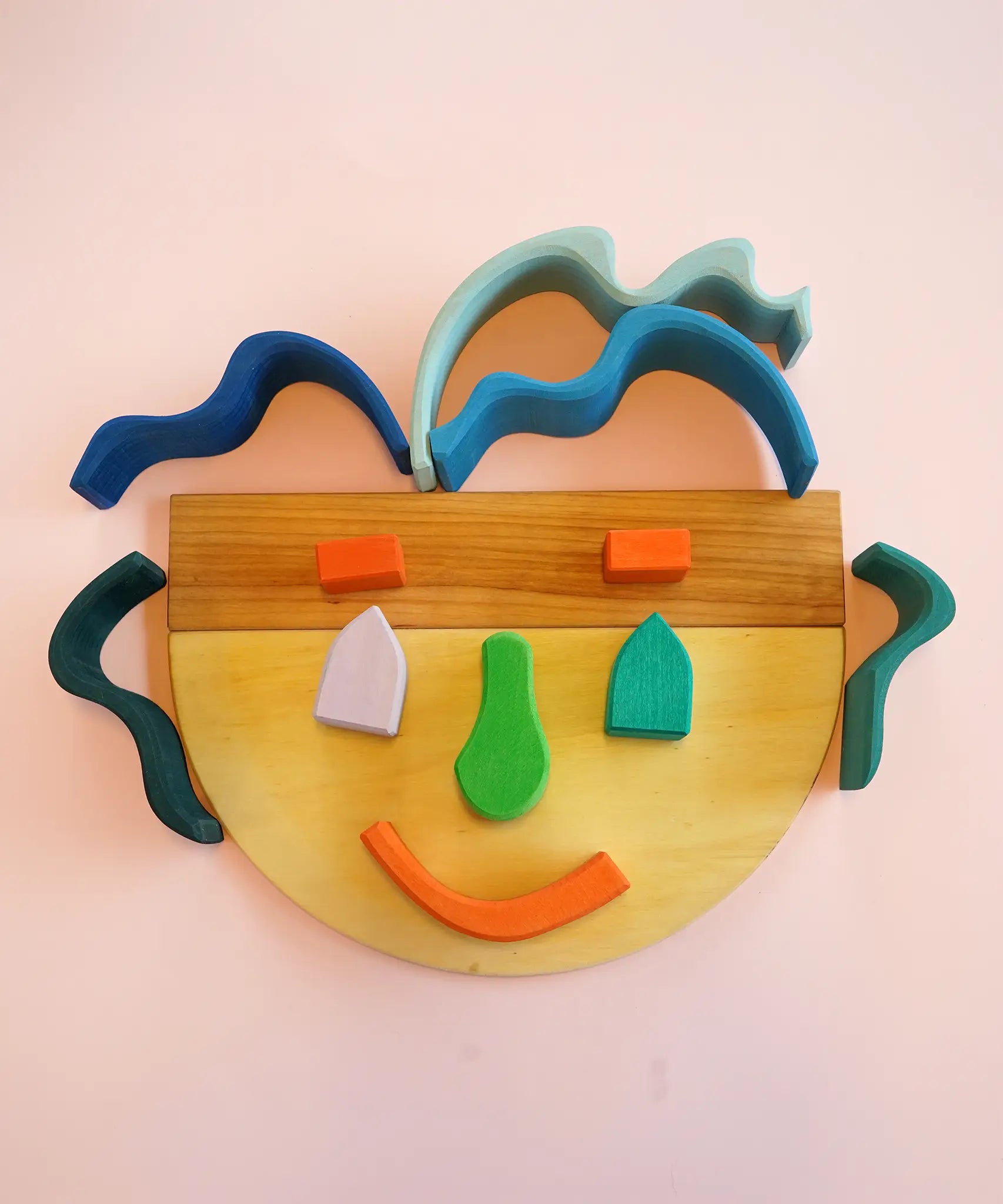 A playful abstract face made from Grimms natural wooden building boards and other building blocks