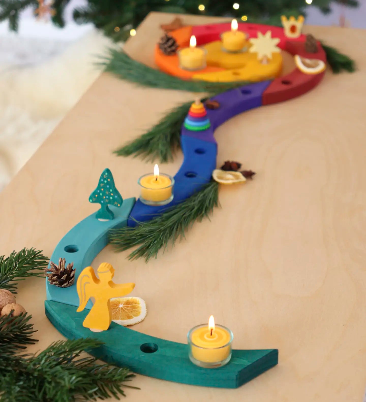 A festive display showing a Grimm's handcrafted wooden celebration spiral pieces and a angel decoration figure