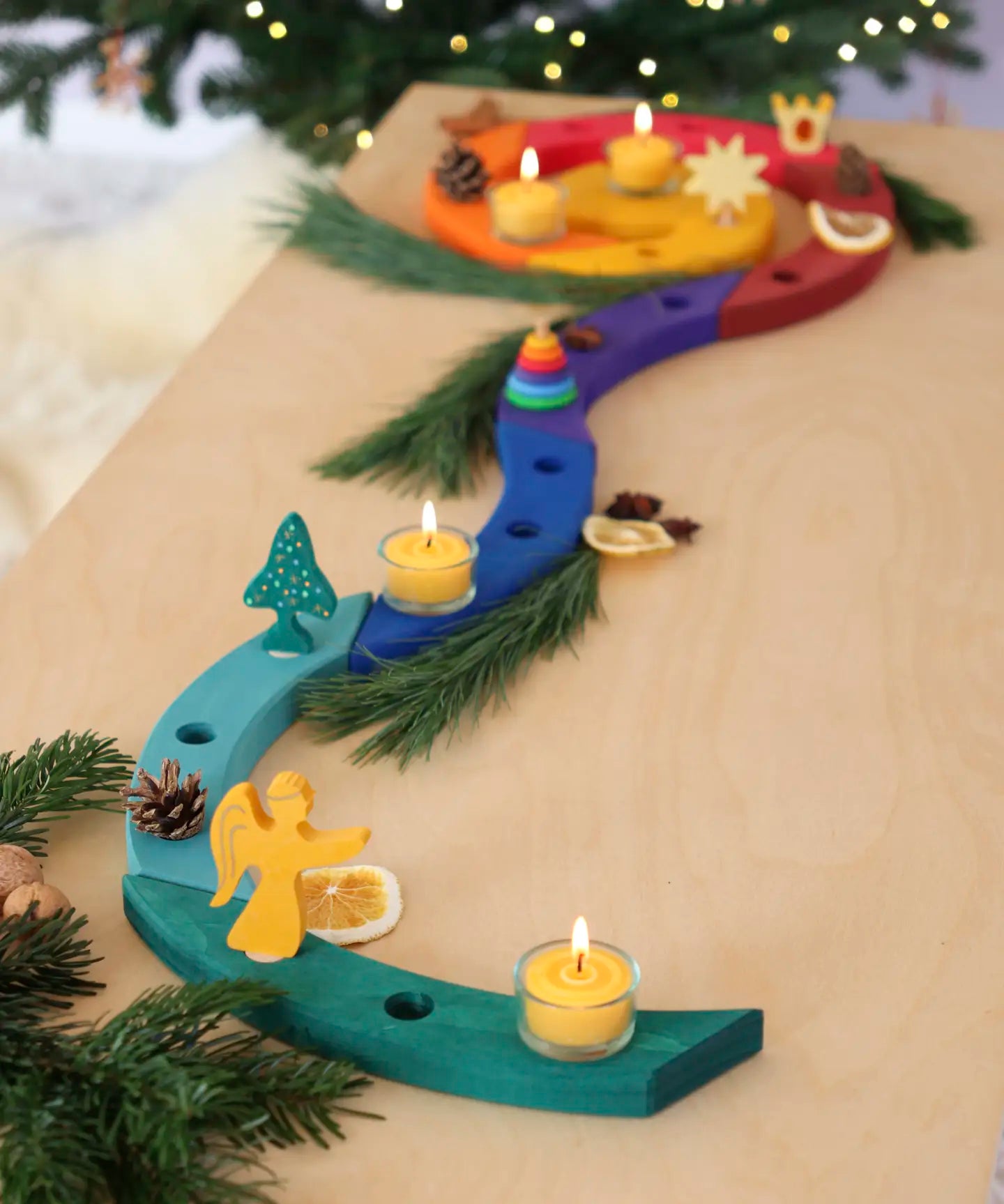 A festive display showing a Grimm's handcrafted wooden celebration spiral pieces and a angel decoration figure