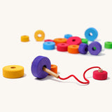Grimms handmade and hand painted wooden first thread game available at Babipur. Features bright and chunky different sized disks with a hole in the middle for the wooden threading needle to string with
