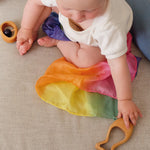 A baby reaching for the Grimm's Grasping Fish With Precious Stones.