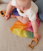 A baby reaching for the Grimm's Grasping Fish With Precious Stones.