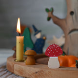 A Grimm's fly agaric red and white mushroom decorative figure placed on a natural celebration ring.