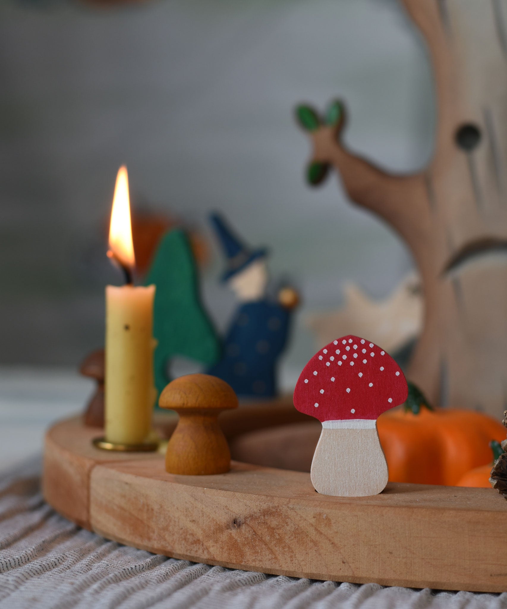 A Grimm's fly agaric red and white mushroom decorative figure placed on a natural celebration ring.