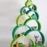 A decorative stack made from the Grimms forest large wooden rainbow 12 piece set and various decorative figures all available at Babipur.