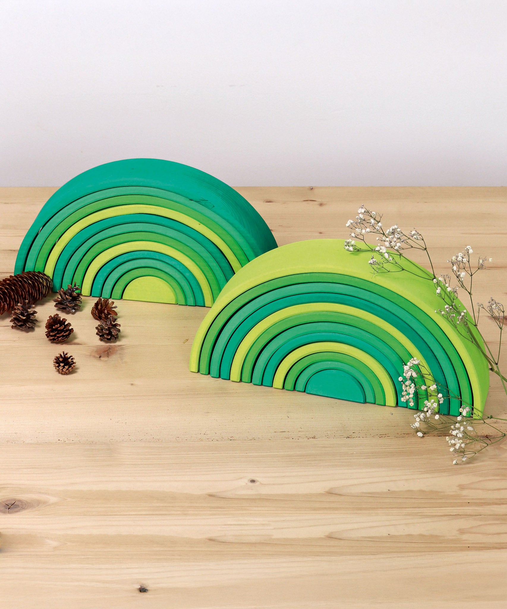 A simple display showing the forest and meadow Grimms green wooden 12 piece rainbow sets. These two are available at Babipur.