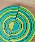 A close up of the Grimms forest and meadow wooden rainbow sets showing the different shades of green for each rainbow. These two are available at Babipur.