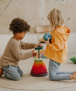 Children stacking wooden blocks from the Grimms Geometric stacking tower set in a playroom