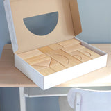 Grimm's giant natural wooden building blocks set in a cardboard box.