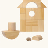 Grimm's giant natural wooden building blocks set used to create a boat shape with the other blocks stacked in the background.