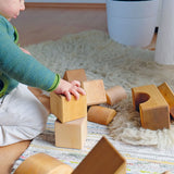 Child playing with Grimm's giant natural wooden building blocks set.