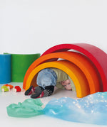 Child crawling underneath a Grimm's Giant Rainbow.