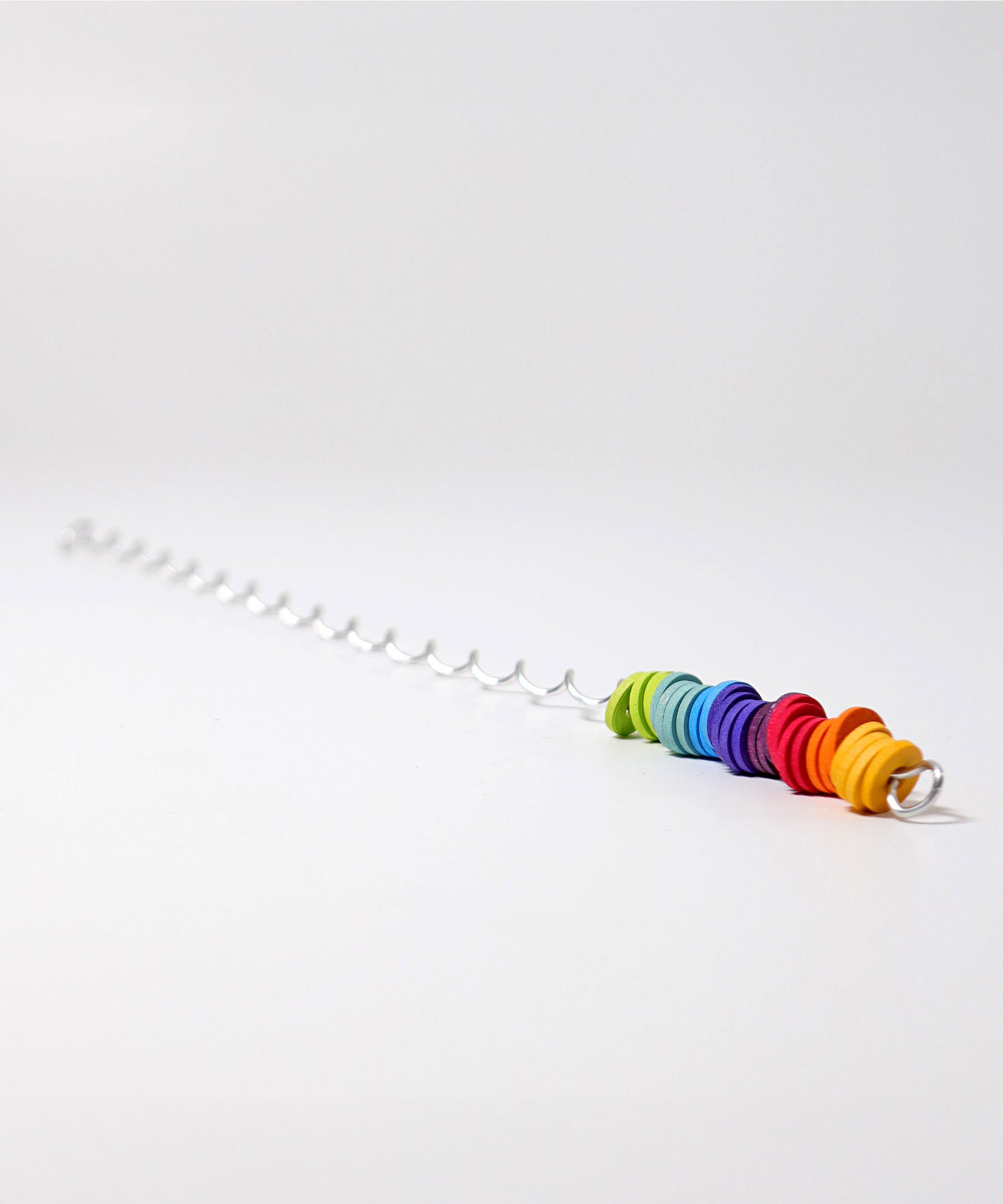 A giant Grimms spirelli available at Babipur. This  winding metal wire comes with coloured wooden disks that make a noise when tipped over. 