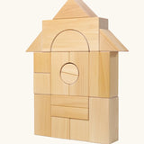 Grimm's giant natural wooden building blocks set used to create a house structure.