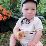 A baby holding the Grimm's Grasping Toy With 5 Rings.