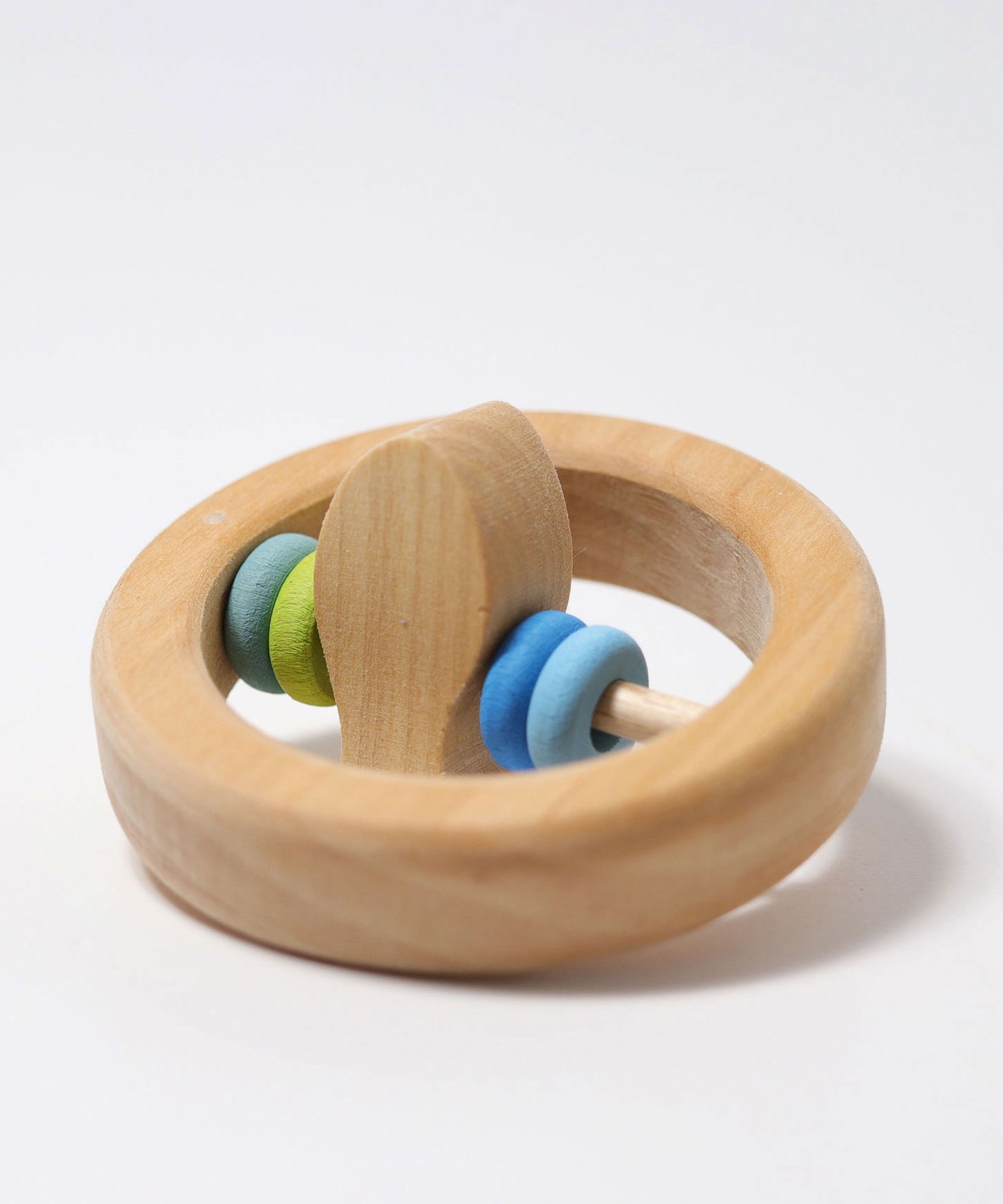 The Grimm's baby Grasping Toy Little Fish With Wooden Discs laid flat with the fish at the center pointing up.