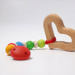 A Grimm's Grasping Toy Smooth Heart attached to a dummy clip.