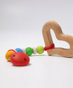 A Grimm's Grasping Toy Smooth Heart attached to a dummy clip.
