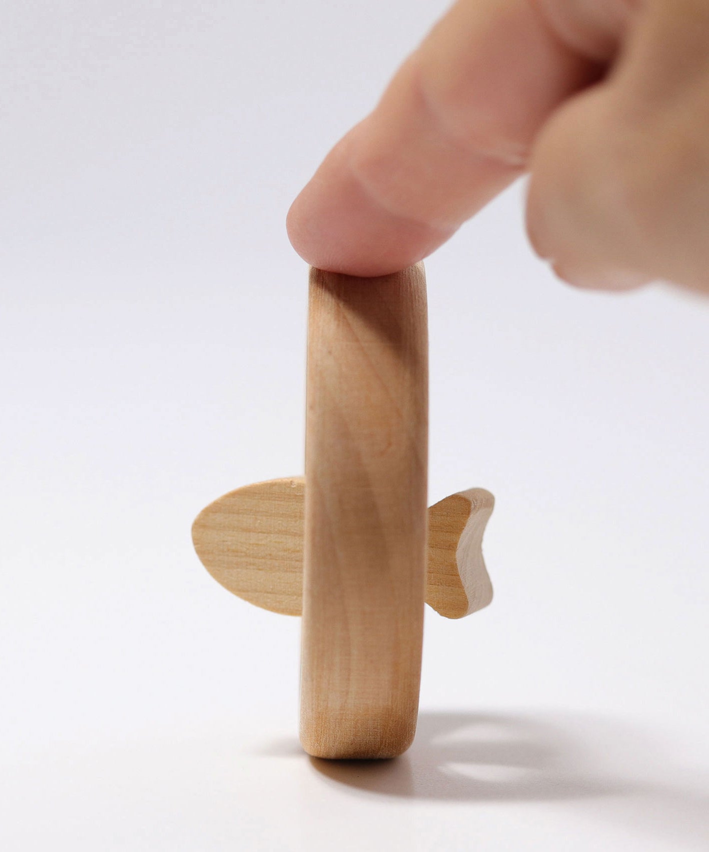 A side profile photo of the Grimm's baby Grasping Toy Little Fish With Wooden Discs.