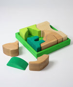 Grimm's green squirrel Building Set. Wooden blocks in various shades of green and natural wood in a green coloured wooden storage tray. These Grimm's toys are part of a wide range of wooden toys available here at Babipur. 
