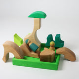 A small world play scene created using the pieces from the Grimm's green squirrel building set with friends wooden peg dolls. These Grimm's toys are part of a wide range of wooden toys available here at Babipur. 