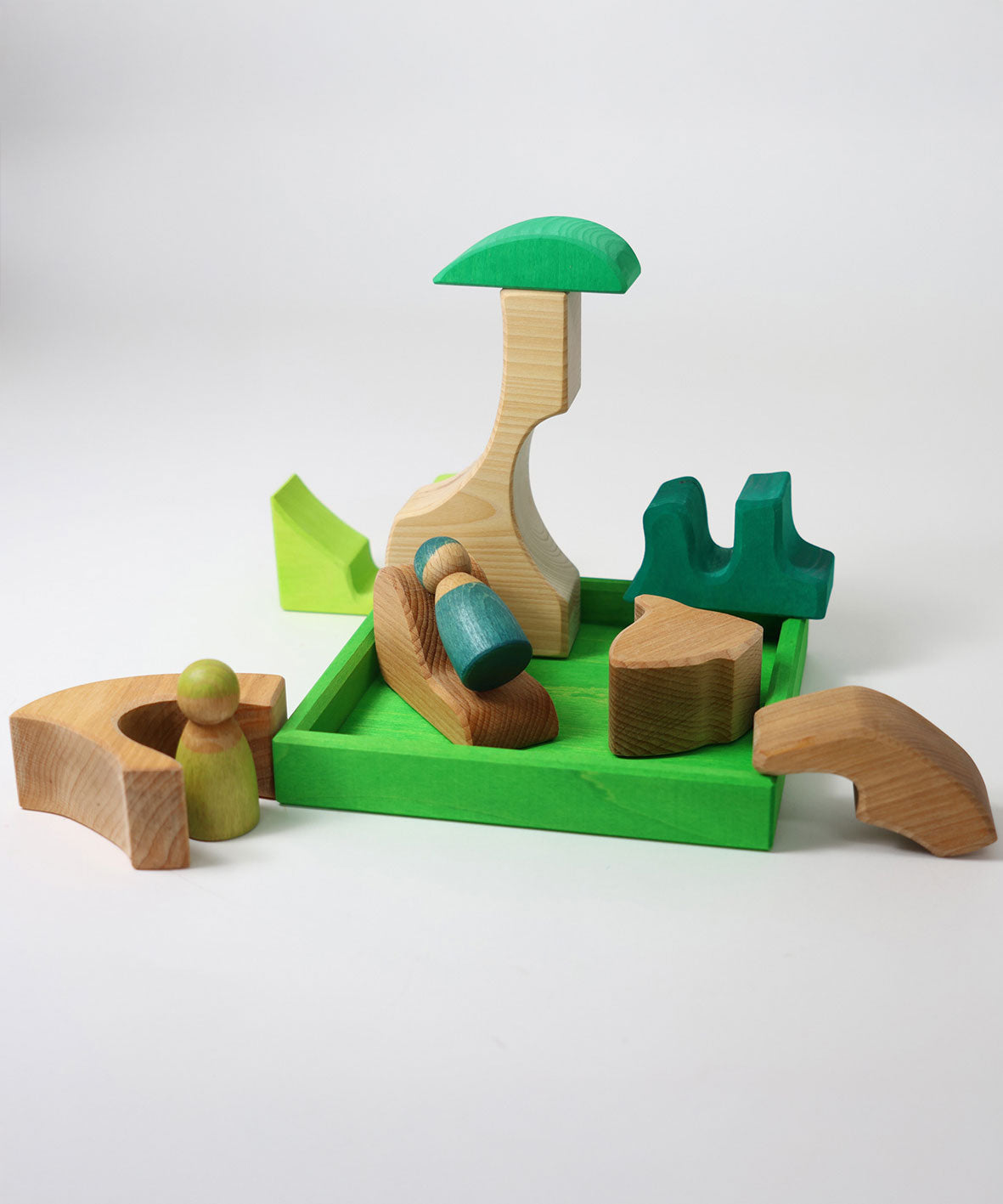 A small world play scene created using the pieces from the Grimm's green squirrel building set with friends wooden peg dolls. These Grimm's toys are part of a wide range of wooden toys available here at Babipur. 