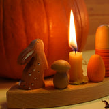 A cosy Autumn inspired display using a Grimm's Waldorf Celebration Ring, Grimm's Candles, a Bumbu rabbit figure and various Grapat pieces available at Babipur.