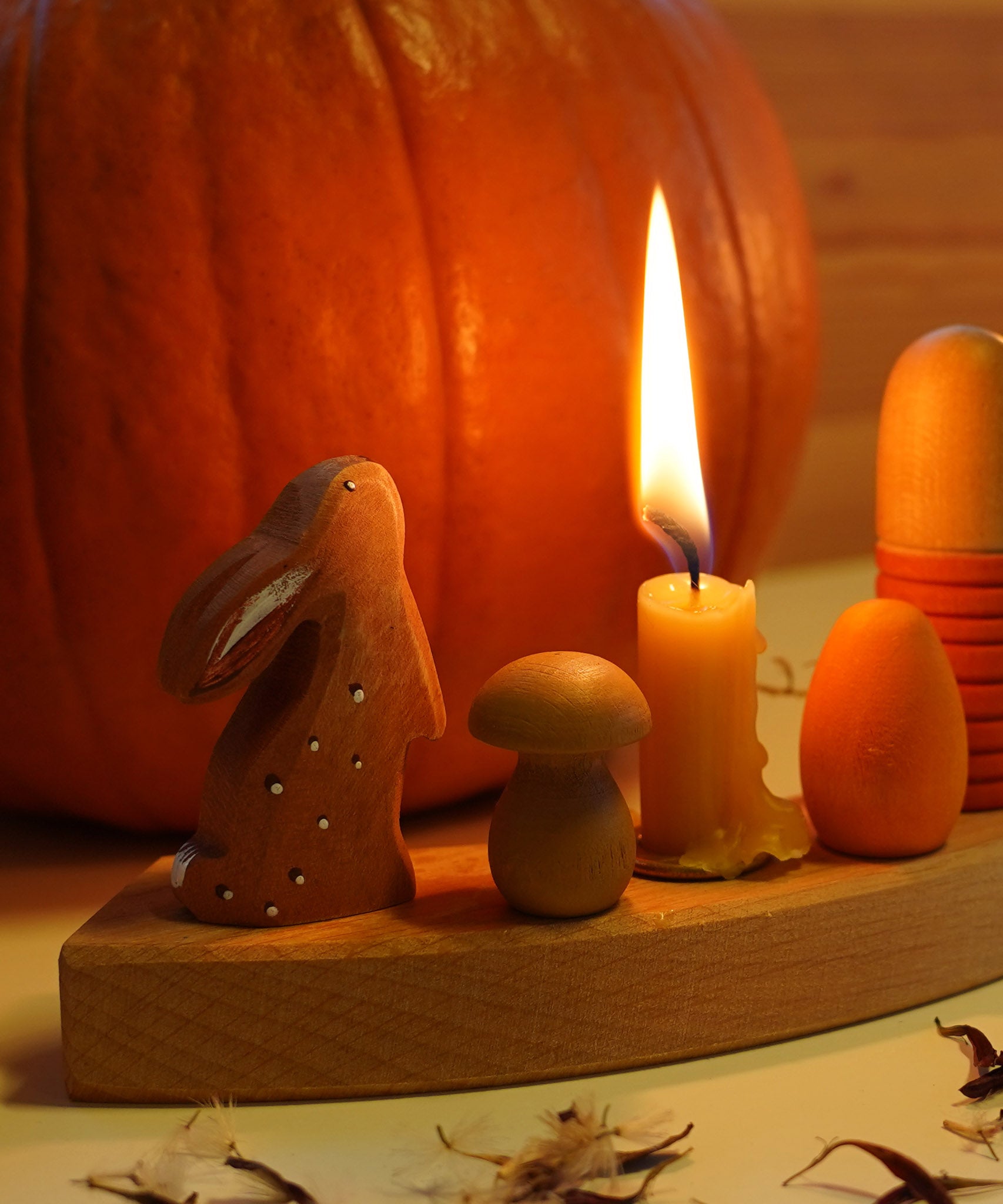 A cosy Autumn inspired display using a Grimm's Waldorf Celebration Ring, Grimm's Candles, a Bumbu rabbit figure and various Grapat pieces available at Babipur.
