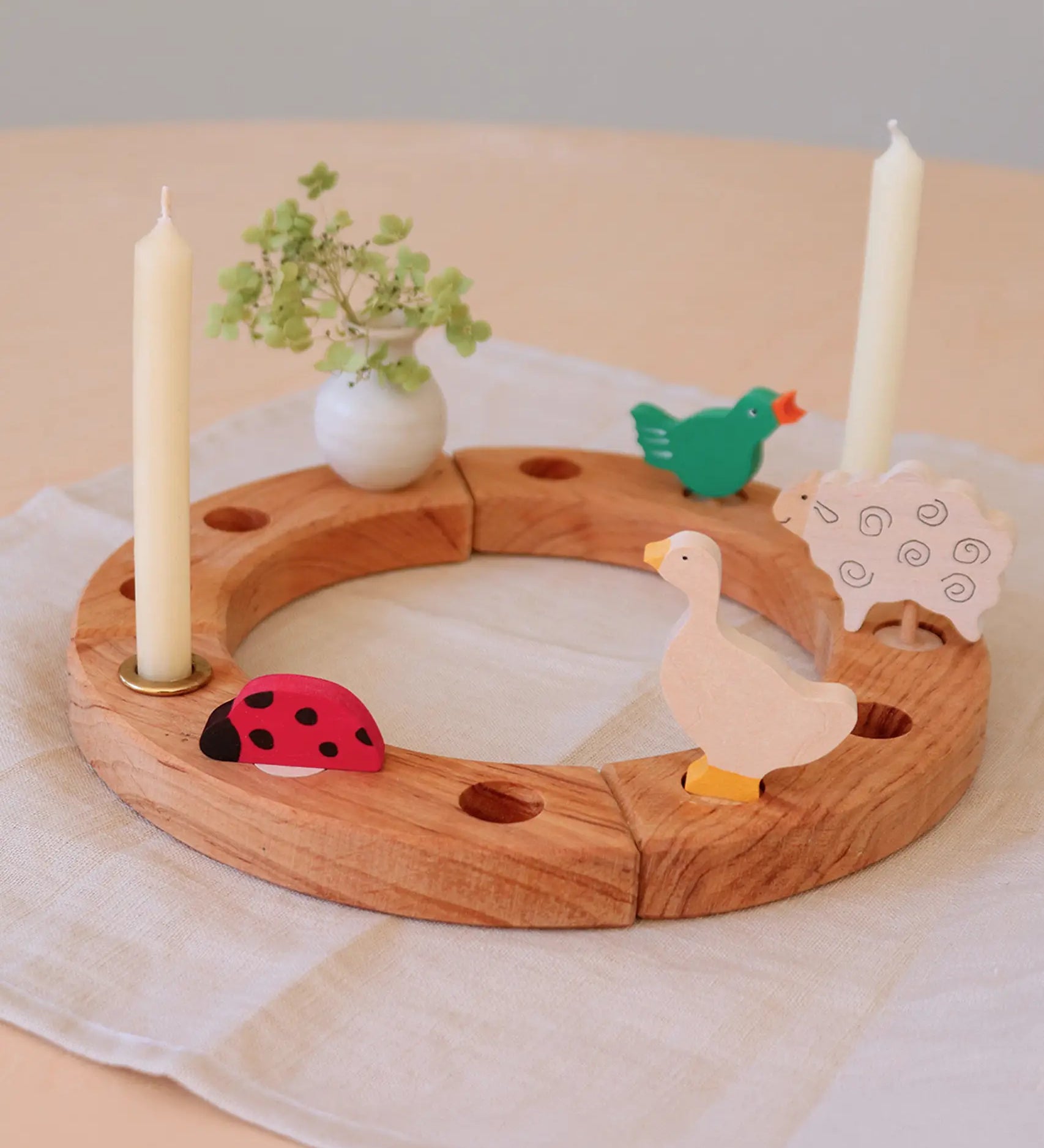 Grimm's wooden celebration ring with a ladybird, white vase, goose, signing bird and sheep decorative figures