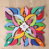 Grimm's Lara Mandala Building Set blocks used to create a square flatlay with little gems placed on top.