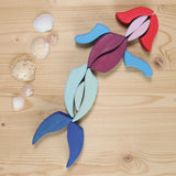 Grimm's Lara Mandala Building Set bloacks used to create a mermaid with seashells placed next to it.