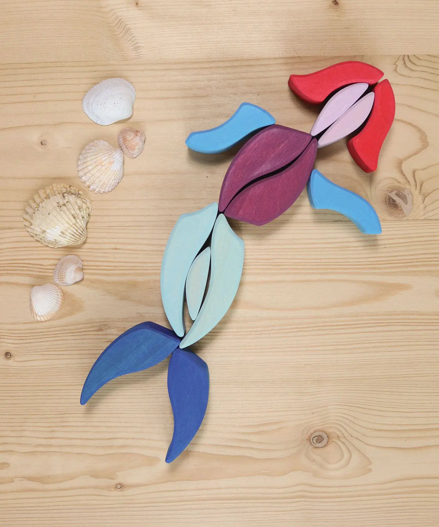 Grimm's Lara Mandala Building Set bloacks used to create a mermaid with seashells placed next to it.