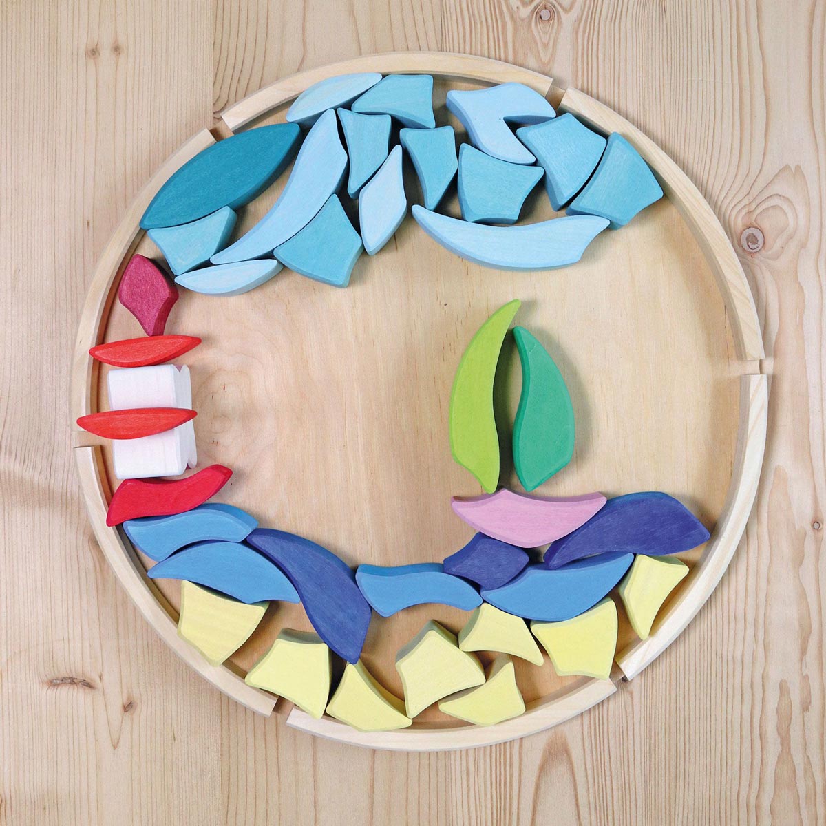 Grimm's wooden Lara toy blocks set laid out in a sailing boat scene on its wooden base.