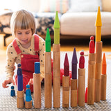 Child playing with the Grimm's large wooden building rollers in natural.