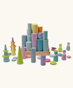 Grimm's large building rollers pastel in a wooden storage tray surrounded by other wooden Grimm's pastel toys.