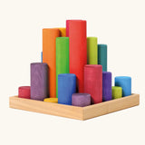 Grimm's large building rollers in bright rainbow colours in a wooden storage tray.