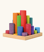 Grimm's large building rollers in bright rainbow colours in a wooden storage tray.