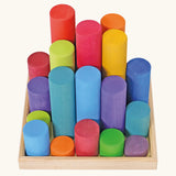 Grimm's large building rollers in bright rainbow colours in a wooden storage tray.