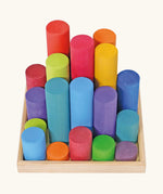 Grimm's large building rollers in bright rainbow colours in a wooden storage tray.
