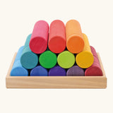 Grimm's large building rollers in bright rainbow colours in a wooden storage tray.