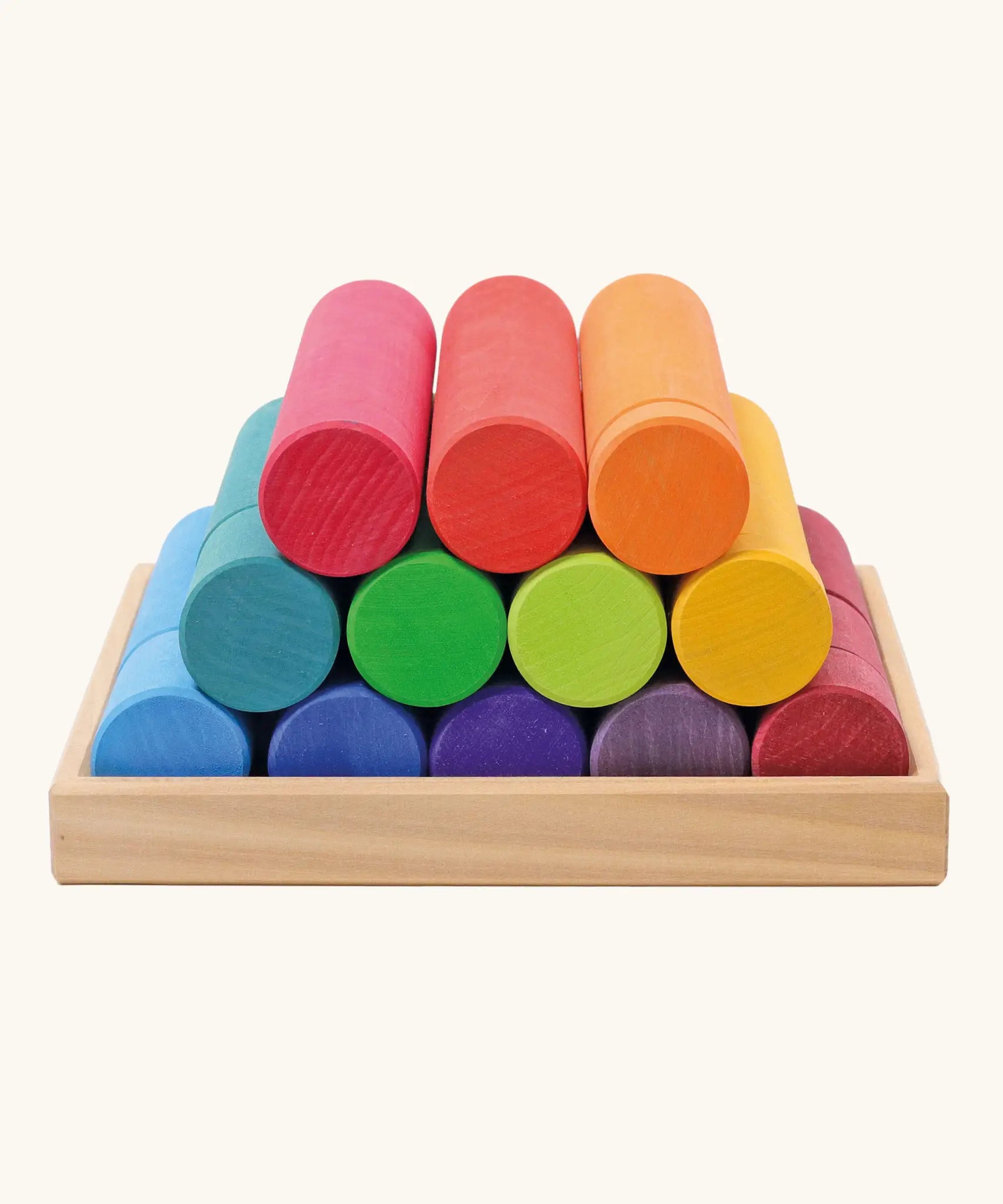 Grimm's large building rollers in bright rainbow colours in a wooden storage tray.