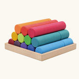 Grimm's large building rollers in bright rainbow colours in a wooden storage tray.