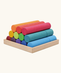 Grimm's large building rollers in bright rainbow colours in a wooden storage tray.