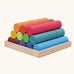 Grimm's large building rollers in bright rainbow colours in a wooden storage tray.